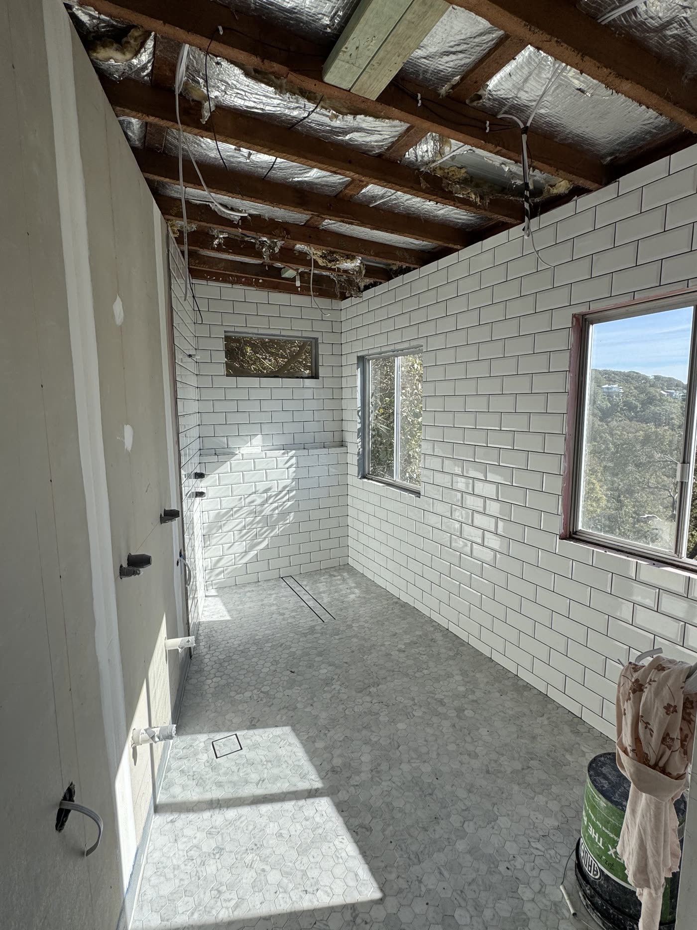 White subway wall tiling and mosaic floor tiling mid-renovation