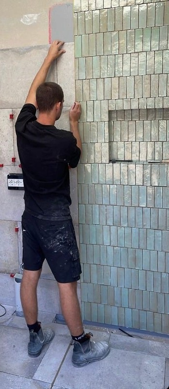 Beck Tiling setting handmade green wall tiles onto a prepared substrate